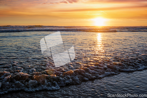 Image of Atlantic ocean sunset with surging waves at Fonte da Telha beach, Portugal