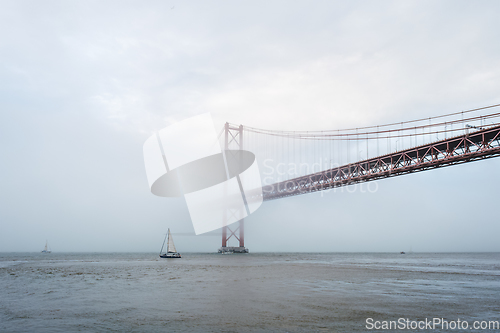 Image of View of 25 de Abril Bridge famous tourist landmark of Lisbon in heavy fog mist