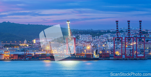 Image of View of Lisbon port with ship and port cranes in the evening