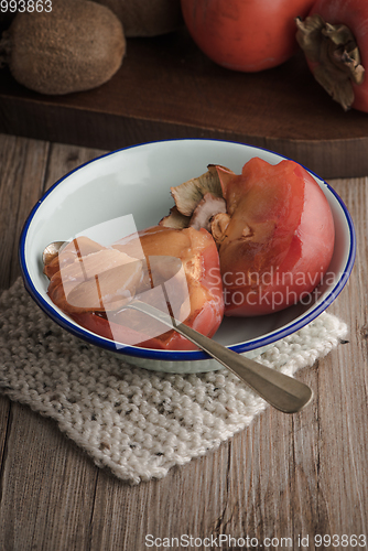 Image of Persimmon fruit on rustic table