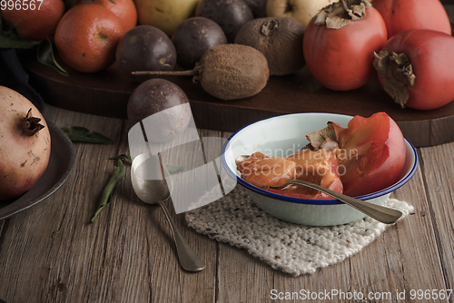 Image of Persimmon fruit on rustic table