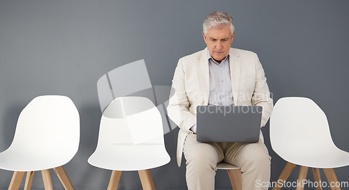 Image of Mature business man, laptop and waiting room, queue and interview line of opportunity, recruitment process or mockup. Executive manager working on technology at studio wall, computer or hiring worker