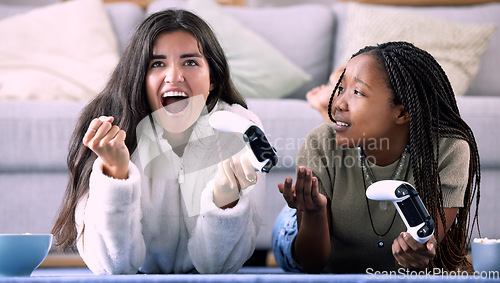 Image of Celebrate, controller and friends playing a game in the living room for entertainment, fun and bonding. Happy, celebration and interracial women enjoying a gaming competition together at their home.