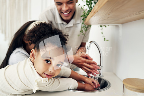 Image of Portrait of a girl washing her hands with her family in the kitchen of their modern home. Happy, smile and child cleaning her hand with her father to get rid of bacteria, germs and dirt in a house.