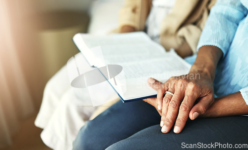 Image of Hands, bible and senior couple praying in their home together for scripture, faith and trust. Family, worship and praise with elderly man and woman united in prayer, holy or gratitude to Jesus Christ