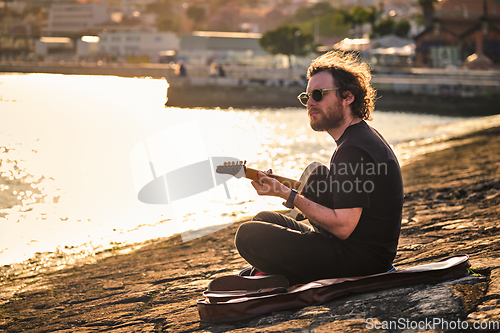 Image of Street musician playing electric guitar in the street