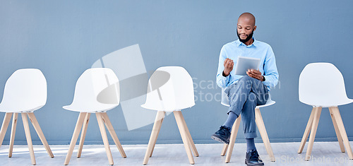 Image of Tablet, waiting room and black man sitting for job search opportunity, career application or Human Resources. Professional person or worker alone with online technology for hr recruitment or hiring