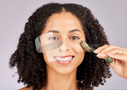 Image of Jade facial roller, portrait and face skin glow of a black woman with beauty stone tool in studio. Wellness, dermatology and young model with spa, skincare and happiness from cosmetics treatment