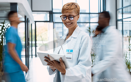 Image of Tablet, doctor and black woman in busy hospital or clinic for research, telehealth or online consultation. Healthcare app, technology and smile of happy senior medical professional with touchscreen.