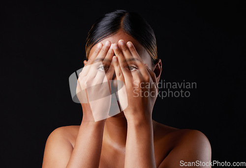 Image of Hiding, shame and portrait of a woman covering face isolated on a black background in a studio. Shy, fear and girl with hands to cover eyes, an expression or insecurity about skin on a dark backdrop