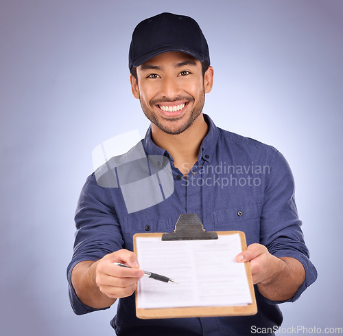 Image of Delivery, signature and portrait of Asian man with paperwork isolated on a studio background. Happy, showing and courier asking to sign a document for approval of a service, import or package