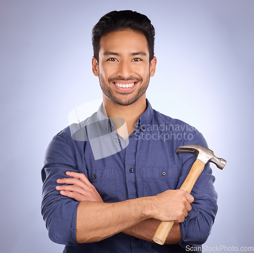 Image of Man, studio and portrait with tools or hammer for handyman, maintenance or repair work with smile. Happy asian model person on purple background arms crossed for engineer, mechanic or technician job