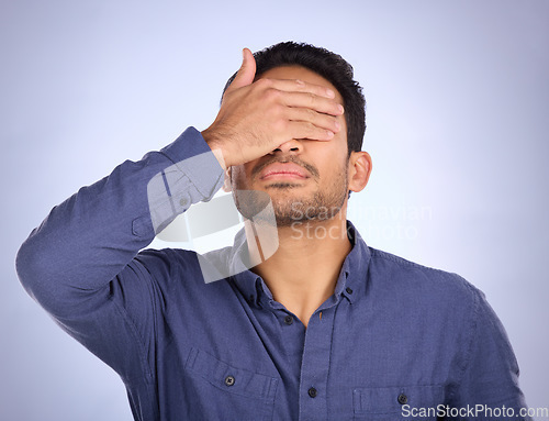 Image of Hand, face and regret with a man in studio on a gray background feeling disappointed by a mistake. Facepalm, problem and frustrated with a male covering his eyes while annoyed, upset or ashamed