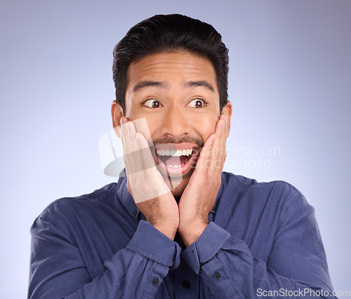 Image of Face, wow and surprise with a man in studio on a gray background looking shocked at an announcement. Hands, notification and omg with a handsome young male feeling surprised or in awe at good news