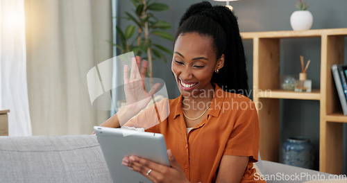 Image of Video call, digital and tablet with black woman greeting virtual meeting while sitting on her sofa in her living room at home. Hello, communication and smile with young female and online conversation