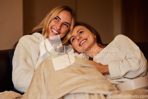 Image of Comfy, laughing and lesbian couple watching tv on the sofa, movie or subscription service. Happy, together and friends relaxing on the couch for television, a show or streaming a funny video