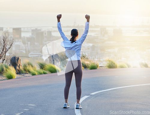 Image of Run celebration, woman workout and fitness goal of a excited and happy runner on a road. Cityscape sunset, freedom and motivation of a female athlete back feeling exercise success from running