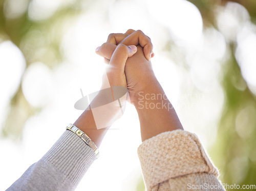 Image of Hand, support or trust with people outdoor together on a nature green background with lens flare in summer. Friends, hope and motivation with women holding hands in unity or solidarity outside