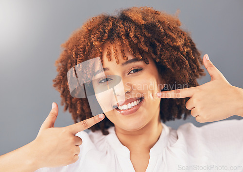 Image of Portrait, teeth and black woman pointing, excited and dental hygiene against grey studio background. Face, Jamaican female and girl with smile, oral health and gesture to dimples, mouth and wellness