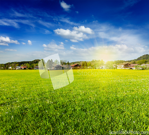 Image of Countryside meadow field with sun and blue sky