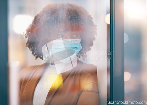 Image of Covid, window and thinking with a business black woman in her office, standing by a glass pane alone. Idea, safety and mask with a female employee in her workplace during the corona virus pandemic