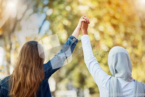 Image of Support, love and women holding hands for unity, trust and solidarity in nature while on a walk. Freedom, multicultural and female friends with an affection gesture while walking in a park or garden.