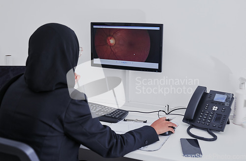 Image of Woman optometrist, retina and medical computer for eye analysis, research or lens test diagnosis. Optician, technology and muslim doctor monitor screen of cataract, vision analytics or health anatomy