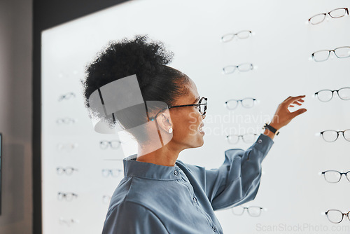 Image of Vision, optometry and black woman shopping for glasses, spectacles or frames at optical store. Eye care, ophthalmology and happy female customer with choice or decision for retail lenses or eyewear.