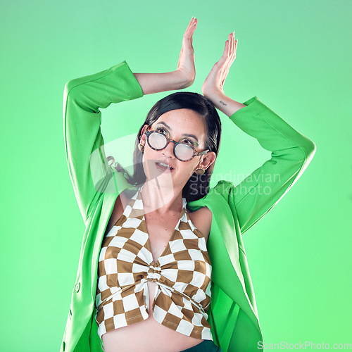 Image of Gen z, queen and woman with hand crown isolated on a green background in a studio. Thinking, royal and girl model with a trendy idea, arrogant expression and edgy with a gesture on a backdrop