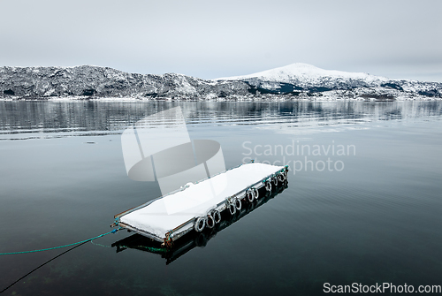 Image of snowy floating jetty on clear sea