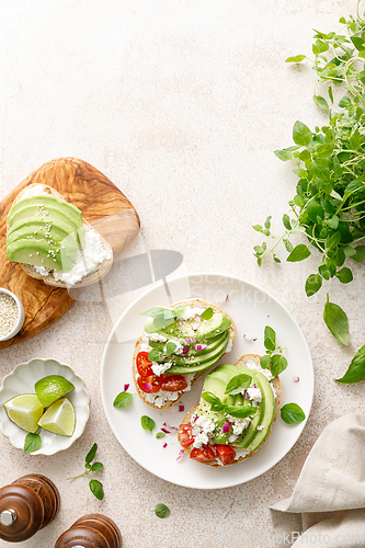 Image of Avocado toast with cheese cottage, tomato and herbs for breakfast