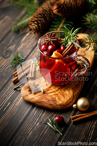 Image of Christmas mulled wine with cranberry, orange, cinnamon, anise and rosemary. Traditional hot drink or beverage, festive Xmas or New Year winter cocktail