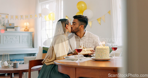 Image of Couple, kiss and gift for birthday celebration, love and happy relationship together at home. Man and woman celebrating special day of birth in bonding happiness with cake and gifts at the table