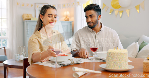 Image of Gift, dinner and couple talking about birthday, anniversary or celebration at a dining room table in house. Happy, smile and young man and woman speaking about present, gratitude and love with food