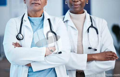 Image of Closeup, doctors and women arms crossed, leadership and confident in hospital, serious and healthcare. Zoom, female employees and medical professional with skills, clinic and teamwork for motivation