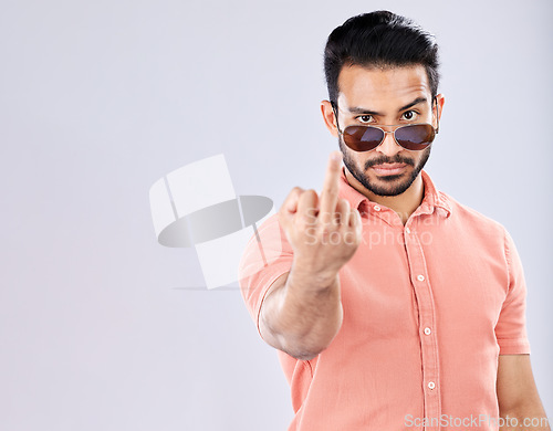 Image of Cool, rude and portrait of an Asian man with a middle finger isolated on a grey studio background. Mockup, angry and mean guy with an offensive hand gesture, expression and space on a backdrop