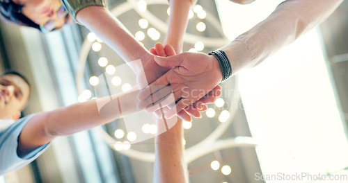 Image of Teamwork, collaboration and low angle of business people with hands together in office. Team building, solidarity and group of employees huddle for unity, union and motivation, goals and targets.