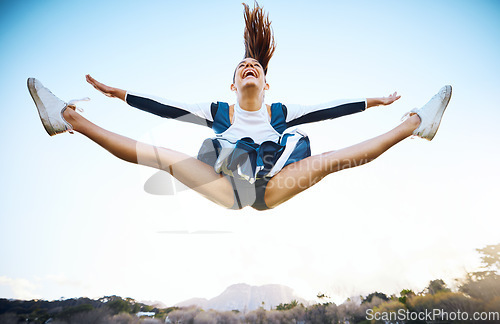 Image of Cheerleader woman, sky and sports performance with smile and energy to celebrate outdoor. Cheerleading person dance or jump stunt while laughing with joy for training workout, freedom or competition