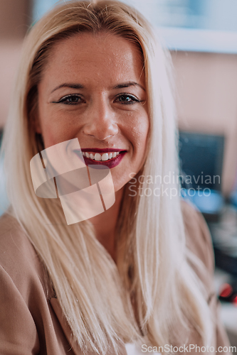 Image of A businesswoman sitting in a programmer's office surrounded by computers, showing her expertise and dedication to technology.