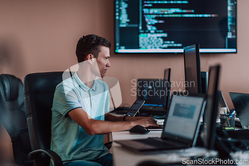 Image of A programmer diligently testing smartphone applications while sitting in their office.