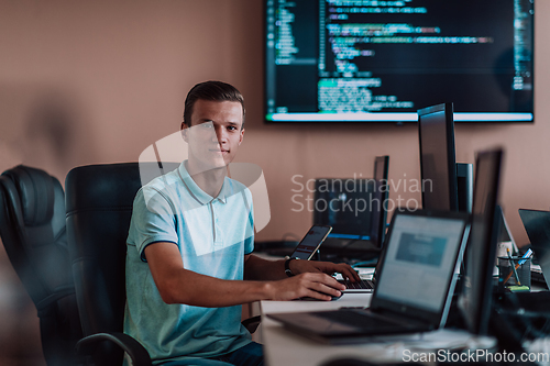 Image of A programmer diligently testing smartphone applications while sitting in their office.