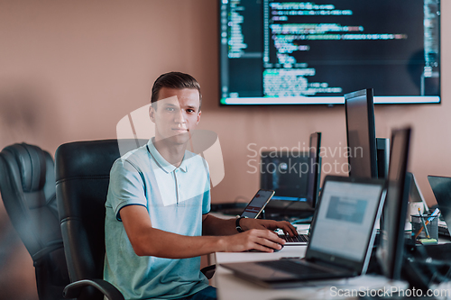 Image of A programmer diligently testing smartphone applications while sitting in their office.