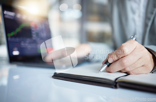 Image of Trader, hands and writing notes in book by laptop on stock market chart or graph statistics for trading at the office. Hand of investor or broker taking note of bitcoin, cryptocurrency or investment