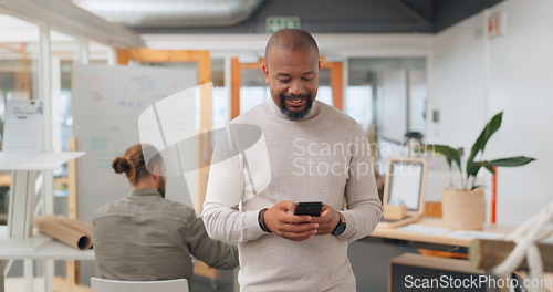 Image of Businessman in office walking, typing on smartphone and greeting people at creative startup. Communication, technology and black man on walk at business checking phone for social media, email or text