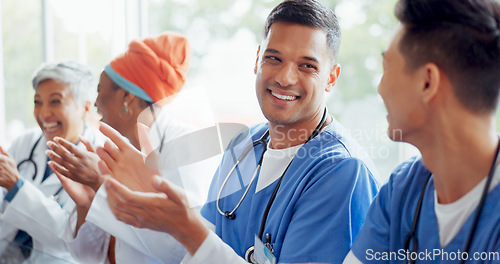 Image of Healthcare, meeting and applause with a doctor man and woman team cheering in a hospital boardroom. Doctors, nurses and medical with a medicine group clapping during a seminar or training workshop