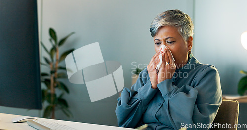 Image of Business woman blowing her nose in the office while working on a report, document or research. Sick, professional and ill senior employee planning a corporate project or proposal in modern workplace.