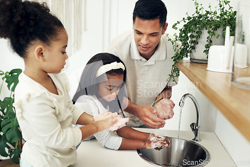 Image of Dad, kids and washing hands in bathroom with soap at tap teaching girls hygiene on morning routine. Water, soap and man with children cleaning dirt, bacteria and germs for health, care and wellness.