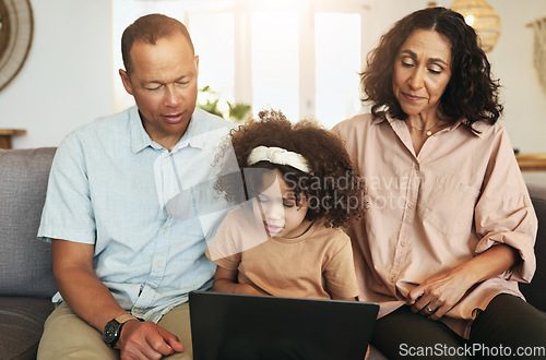Image of Child streaming a movie on laptop with her grandparents while relaxing on sofa in the living room. Technology, rest and girl watching video or film with grandfather and grandmother for entertainment.