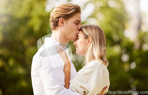 Image of Dating, love and forehead kiss of couple in park for happy, quality time and bond on weekend, vacation and holiday. Romance, relationship and young man and woman relax hugging, kissing and embrace