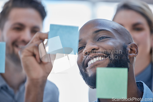 Image of Black man, writing and smile for schedule planning on glass board for team brainstorming or tasks at office. Happy African male smiling in project plan, ideas or sticky note for teamwork strategy